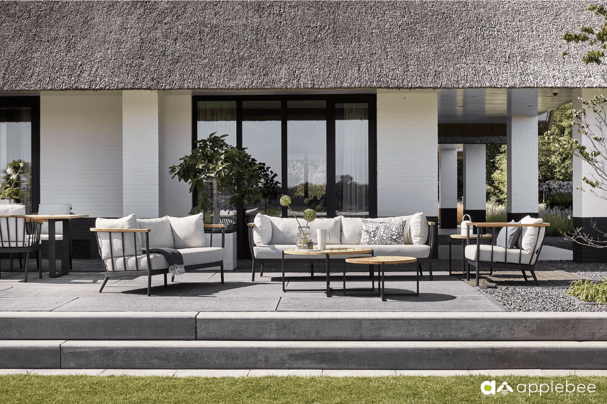 Stijlvolle Apple Bee loungeset met comfortabele kussens en een aluminium frame, prachtig gepresenteerd op een zonnig terras. 