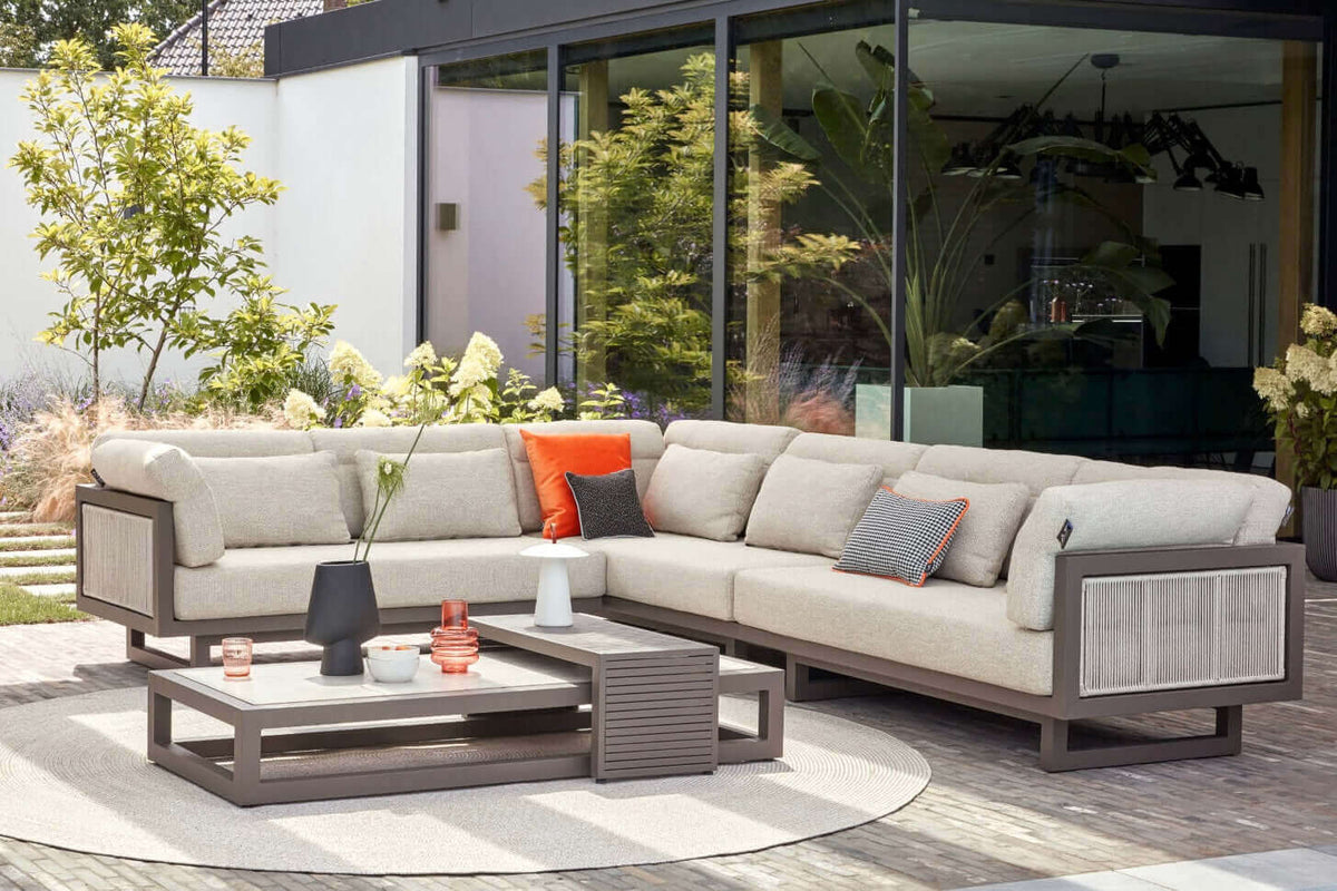 Apple Bee Santorini Rope hoekset in een moderne tuin, chaise longue met kussens en salontafel.