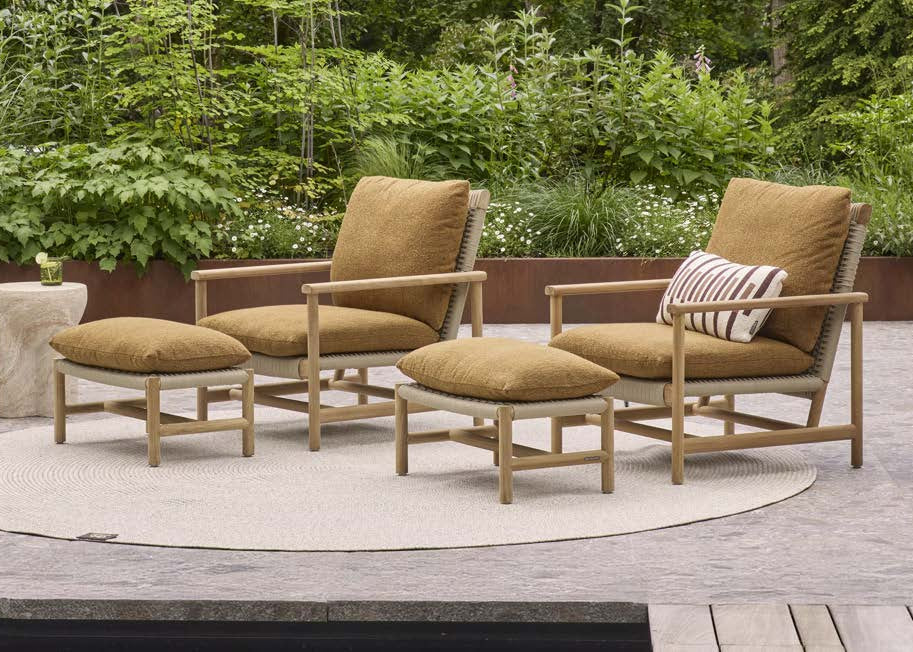 Twee Apple Bee Jamila loungestoelen met hockers in teak en amber op terras